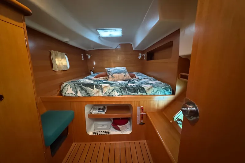 Slide: The Image of Cozy cabin interior of 2000 Lagoon 380 catamaran with wooden finish and patterned bedding. - 15