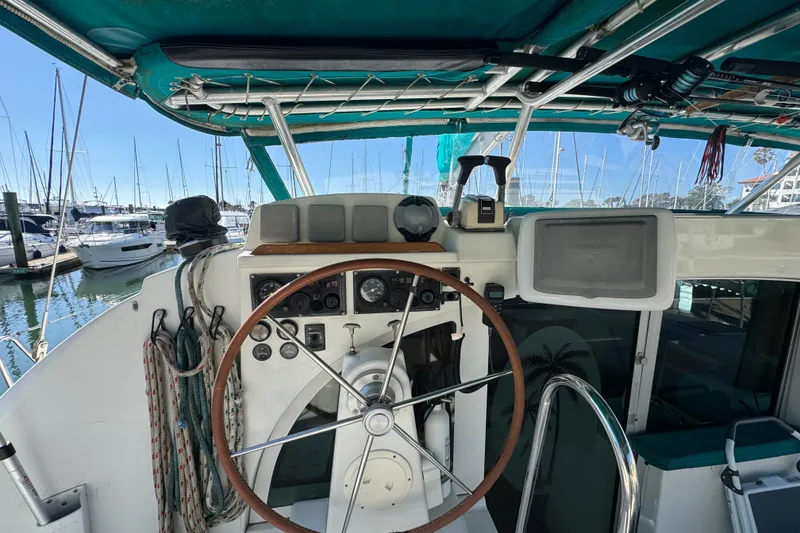 Slide: The Image of Helm of 2000 Lagoon 380 catamaran with steering wheel and navigation equipment in marina. - 20