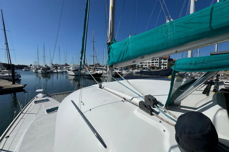 Slide: The Image of Lagoon 380 catamaran from 2000 docked in a marina under clear blue skies. - 22