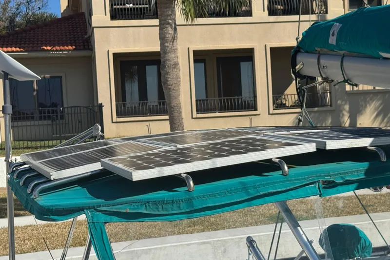 Slide: The Image of Solar panels on Lagoon 380 catamaran, 2000 model, docked near a building. - 23