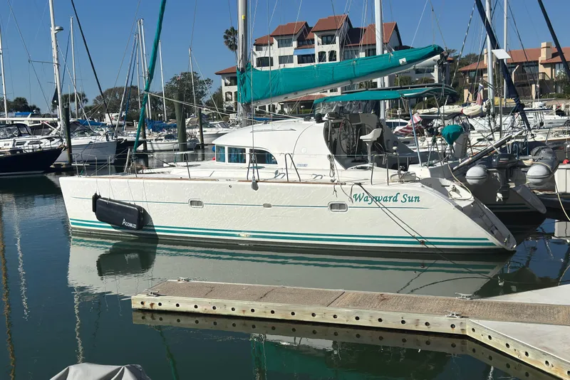 Slide: The Image of Lagoon 380 catamaran, 2000 model, docked in a marina with teal accents. - 26
