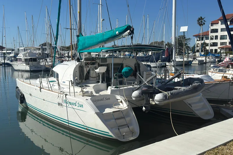 Slide: The Image of Lagoon 380 catamaran from 2000 docked in a marina, surrounded by other boats. - 27
