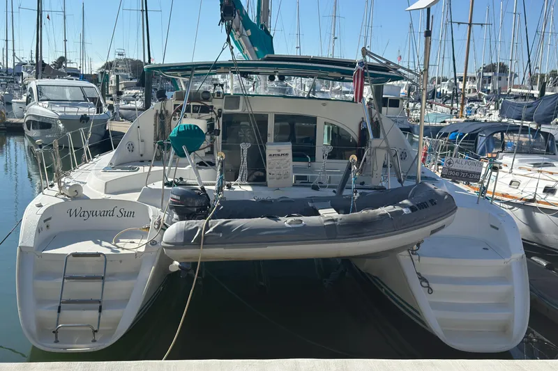 Slide: The Image of Lagoon 380 catamaran from 2000 docked at a marina, surrounded by other boats. - 28