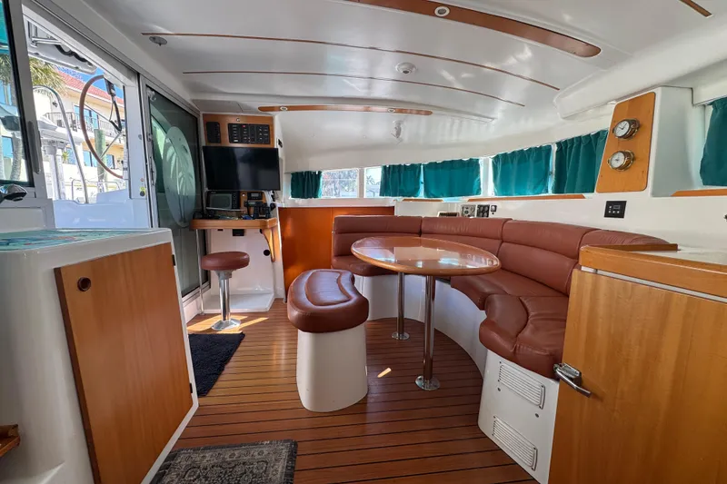 Slide: The Image of Interior of 2000 Lagoon 380 catamaran with wood accents and leather seating. - 30