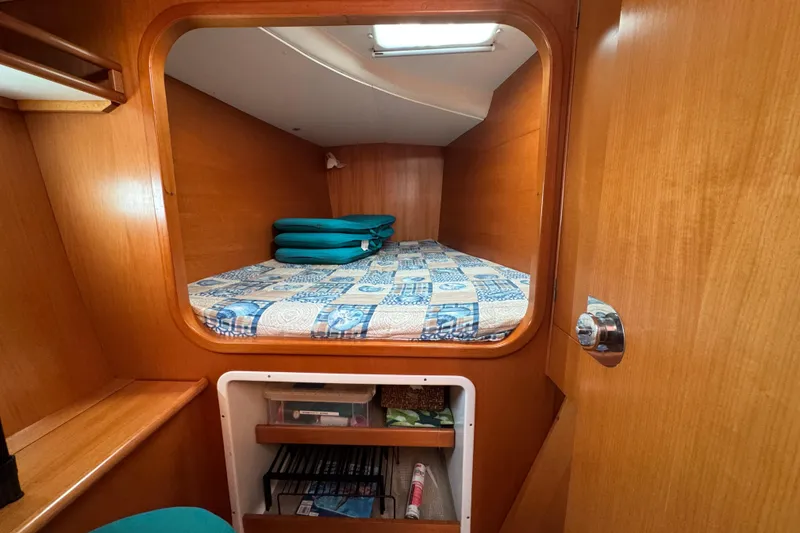 Slide: The Image of Cozy cabin interior of 2000 Lagoon 380 catamaran with wooden finish and patterned bedding. - 8