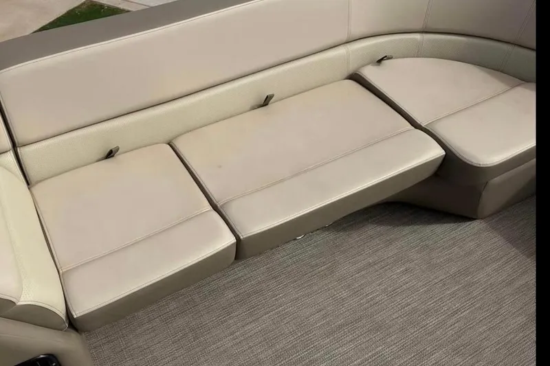 Slide: The Image of 2022 Manitou 25 AURORA LE RF boat interior seating, beige upholstery, and carpeted flooring. - 7