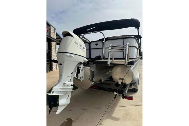 Slide: The Image of 2022 Manitou 25 AURORA LE RF pontoon boat with Suzuki outboard motor on trailer. - 9