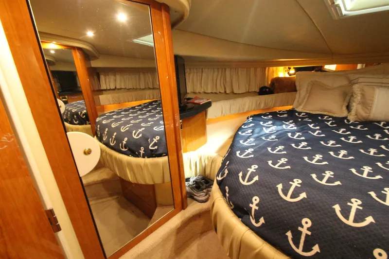 Slide: The Image of Luxurious cabin interior of 2000 Sea Ray 410 Sundancer with nautical-themed bedding. - 34