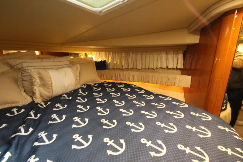 Slide: The Image of Cozy cabin interior of 2000 Sea Ray 410 Sundancer with anchor-themed bedding. - 35