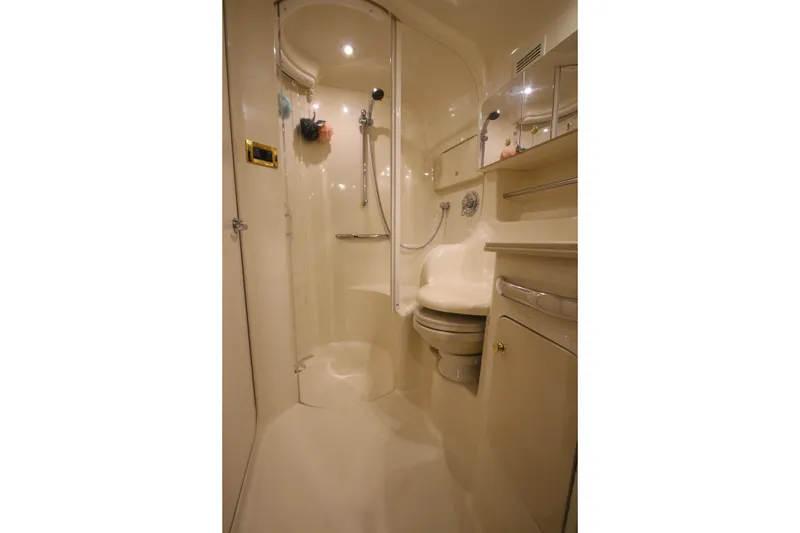 Slide: The Image of 2000 Sea Ray 410 Sundancer bathroom with shower, toilet, and mirrored cabinet. - 38