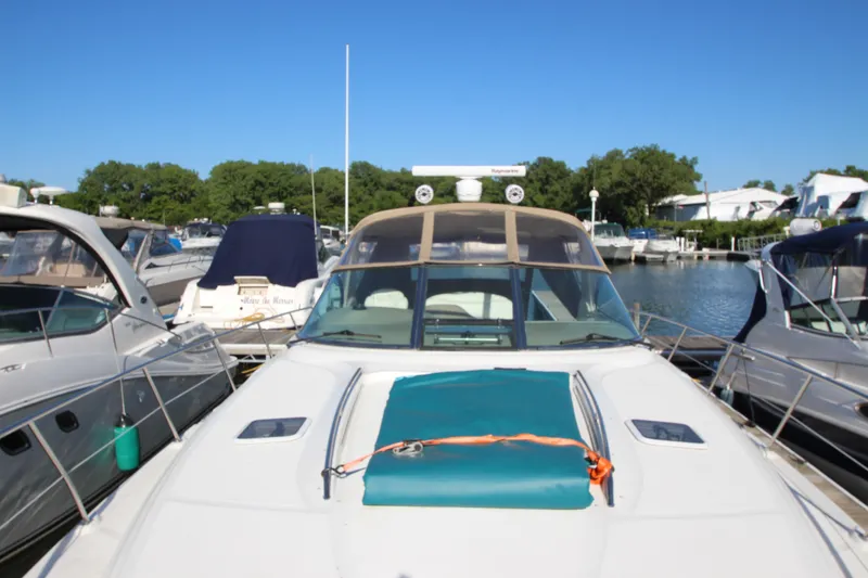 Slide: The Image of 2000 Sea Ray 410 Express Cruiser docked at marina under clear blue sky. - 48