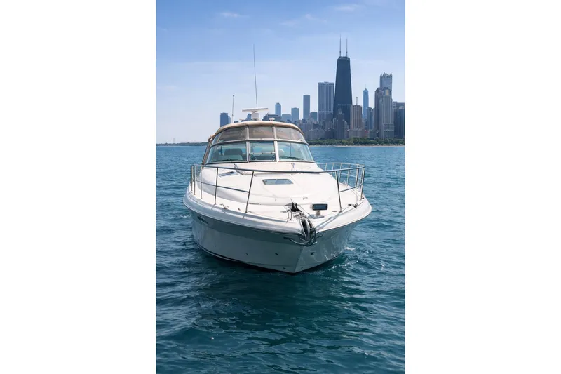 Slide: The Image of 2000 Sea Ray 410 Sundancer yacht on water with city skyline background. - 1