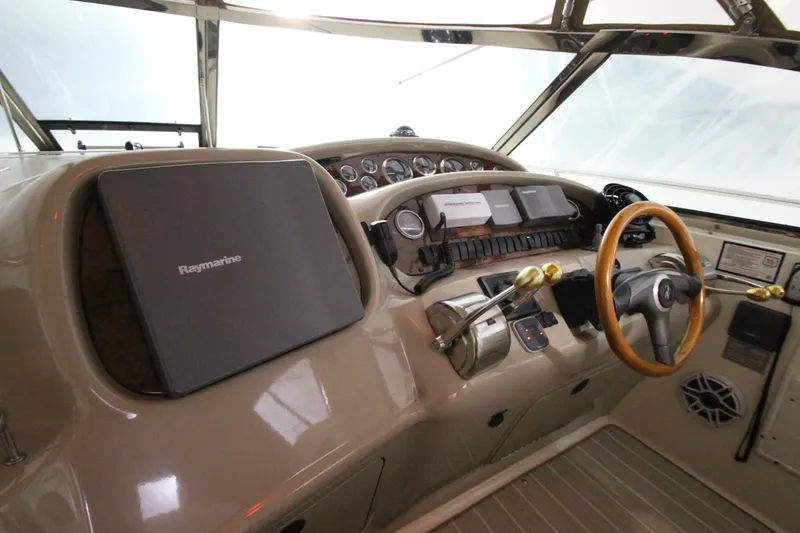 Slide: The Image of Cockpit of 2000 Sea Ray 410 Sundancer with Raymarine navigation system and wooden steering wheel. - 12