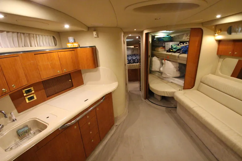 Slide: The Image of Luxurious interior of 2000 Sea Ray 410 Sundancer yacht with kitchen and seating area. - 21