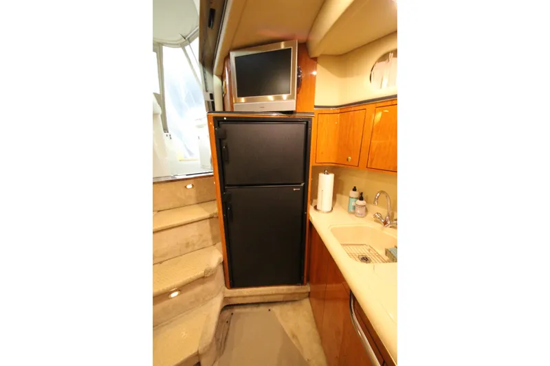 Slide: The Image of 2000 Sea Ray 410 Sundancer yacht interior with kitchenette, fridge, and stairs. - 24