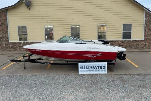 Slide: The Image of Red and white 2011 Starcraft 2018 IO Limited boat on trailer, parked outside building. - 1