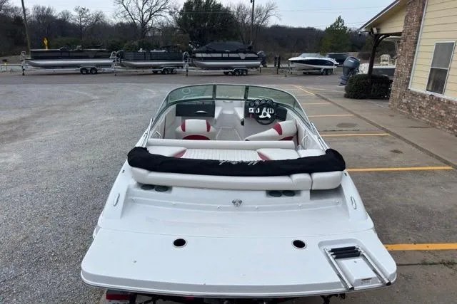 Slide: The Image of White 2011 Starcraft 2018 IO Limited boat parked, rear view, in a lot with other boats. - 2