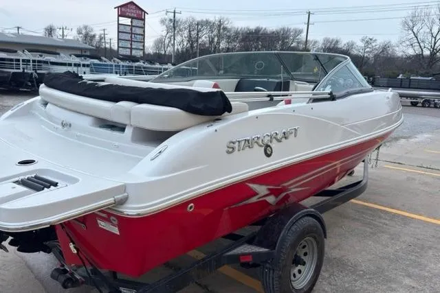 Slide: The Image of Red and white 2011 Starcraft 2018 IO Limited boat on trailer in parking lot. - 4