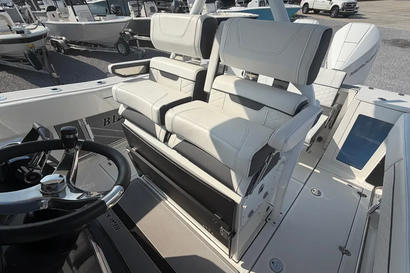 Slide: The Image of 2022 Blackfin 272 CC boat interior with dual helm seats and steering wheel. - 11