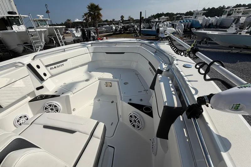 Slide: The Image of 2022 Blackfin 272 CC boat interior with seating and speakers, docked outdoors. - 9