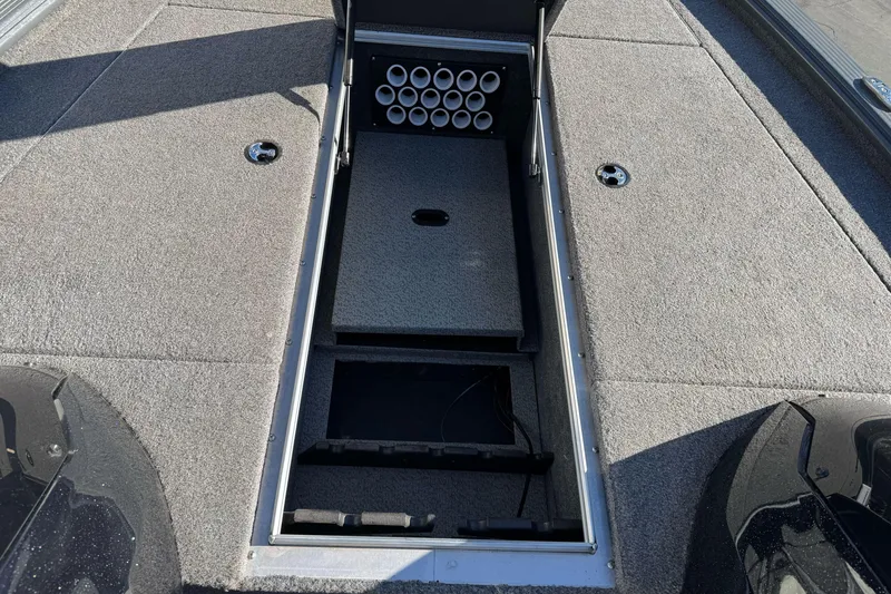 Slide: The Image of 2018 Lund 1875 Pro-V Bass boat interior storage compartment with rod holders. - 18