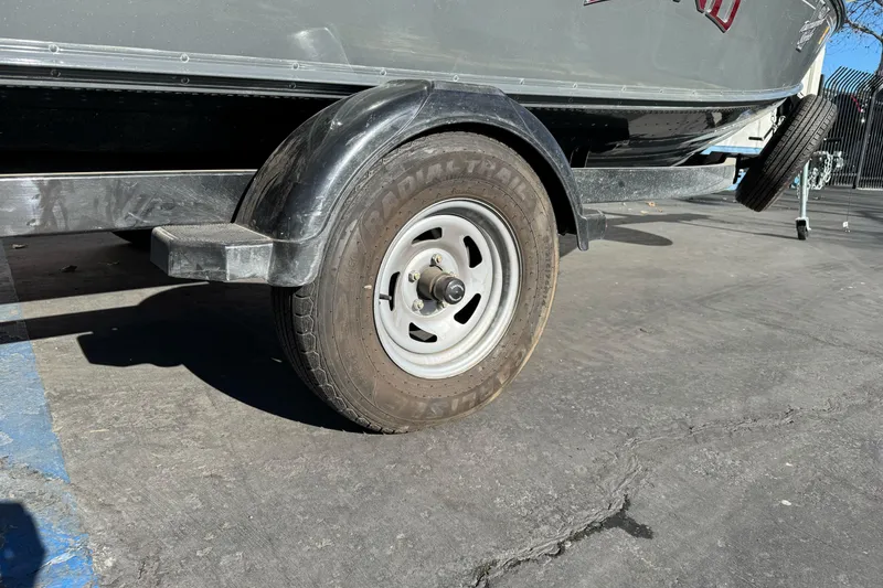 Slide: The Image of 2018 Lund 1875 Pro-V Bass boat trailer tire on pavement. - 2