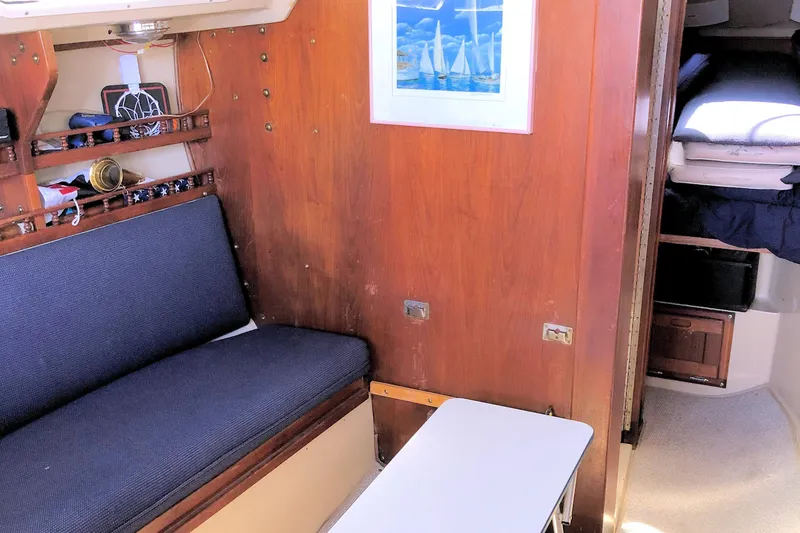 Slide: The Image of Interior of a 1981 Catalina 30 sailboat with wooden paneling and blue seating. - 17