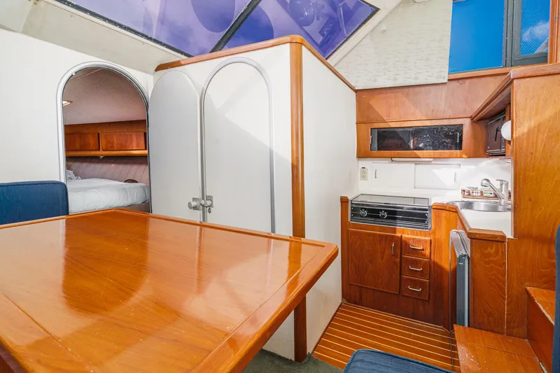 Slide: The Image of Interior of 1989 Pearson 34 Convertible yacht with wood finishes and compact kitchen. - 11