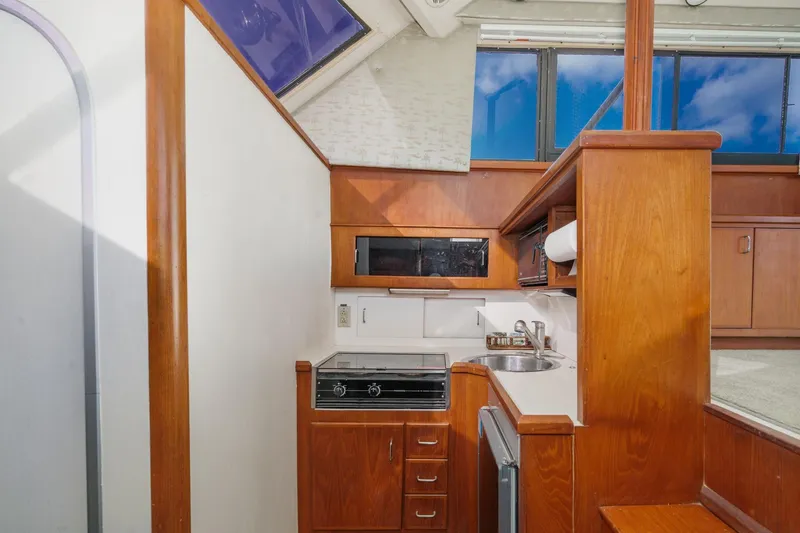 Slide: The Image of 1989 Pearson 34 Convertible yacht kitchen with wood cabinetry, stove, and sink. - 12