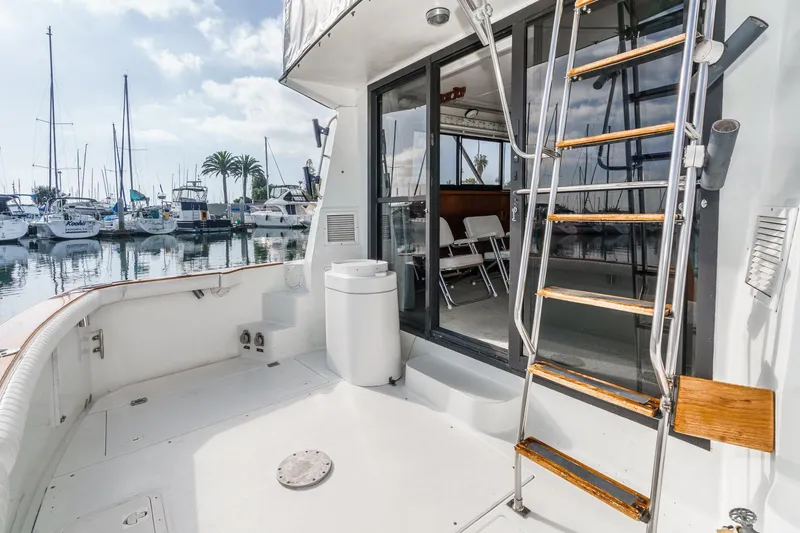 Slide: The Image of 1989 Pearson 34 Convertible yacht deck with ladder, marina view, and sliding glass doors. - 6