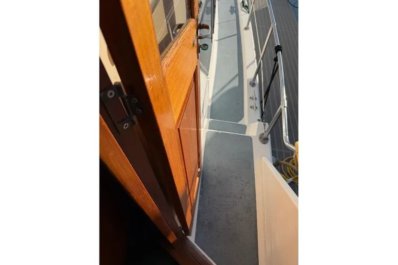 Slide: The Image of 1984 Gulfstar 49 Motor Yacht deck view with wooden door and railing. - 13