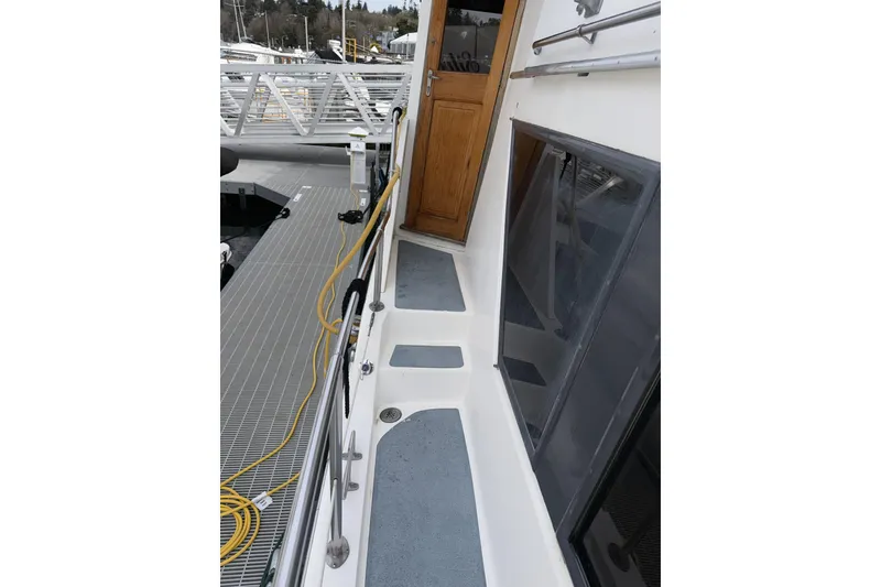 Slide: The Image of 1984 Gulfstar 49 Motor Yacht deck with wooden door and dock view. - 14