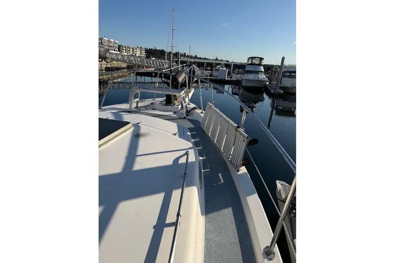 Slide: The Image of 1984 Gulfstar 49 Motor Yacht docked at marina under clear blue sky. - 15