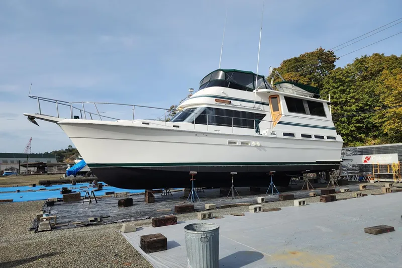 Slide: The Image of 1984 Gulfstar 49 Motor Yacht on dry dock, surrounded by trees and equipment. - 2