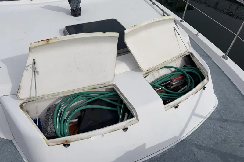 Slide: The Image of Open storage compartments on 1984 Gulfstar 49 Motor Yacht deck, containing hoses and cleaning supplies. - 20