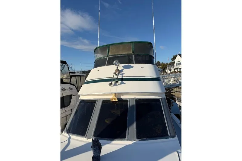 Slide: The Image of 1984 Gulfstar 49 Motor Yacht with green accents docked under clear blue sky. - 23