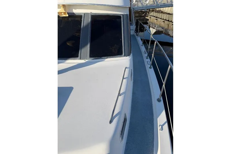 Slide: The Image of 1984 Gulfstar 49 Motor Yacht deck view with railing and windows. - 24