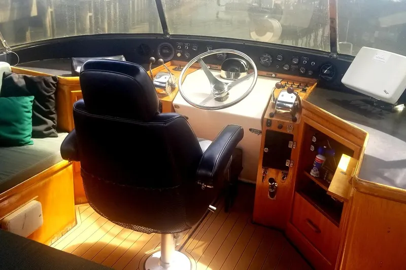Slide: The Image of 1984 Gulfstar 49 Motor Yacht helm with steering wheel, controls, and seating. - 31