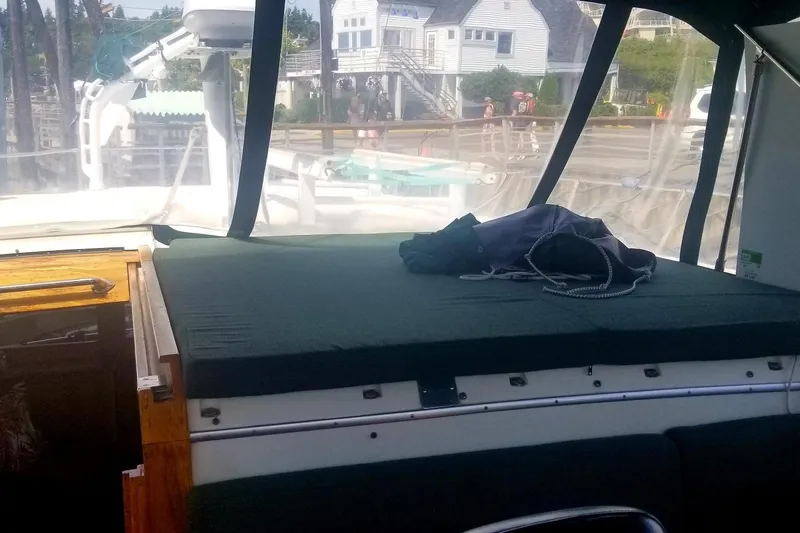 Slide: The Image of 1984 Gulfstar 49 Motor Yacht interior with dockside view, featuring cushioned seating and nautical equipment. - 35