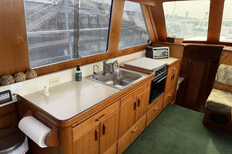 Slide: The Image of Interior of 1984 Gulfstar 49 Motor Yacht kitchen with sink, stove, and wooden cabinetry. - 43