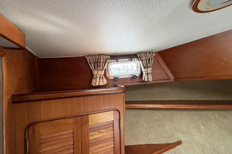 Slide: The Image of 1984 Gulfstar 49 Motor Yacht interior with wood paneling and small window. - 49