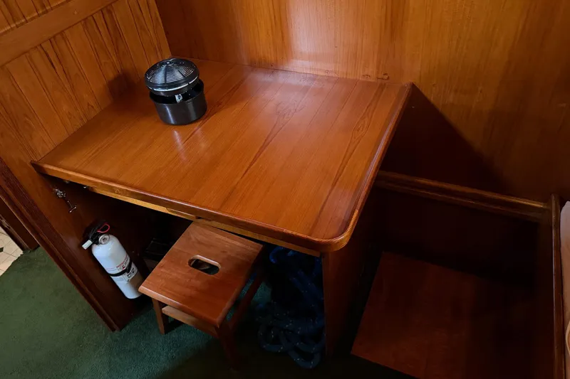 Slide: The Image of Wooden desk area on 1984 Gulfstar 49 Motor Yacht with stool and fire extinguisher. - 61