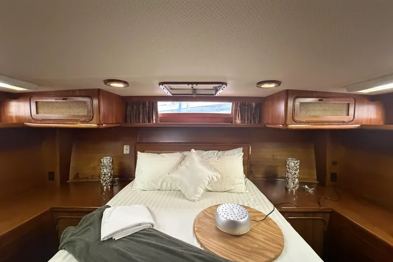 Slide: The Image of Cozy bedroom interior of 1984 Gulfstar 49 Motor Yacht with wood accents and soft lighting. - 62