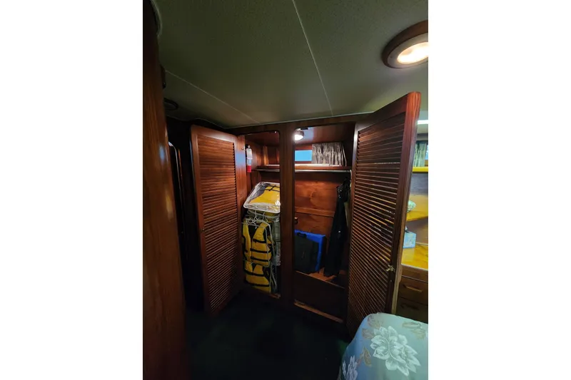 Slide: The Image of 1984 Gulfstar 49 Motor Yacht interior closet with wooden doors and life jackets. - 63