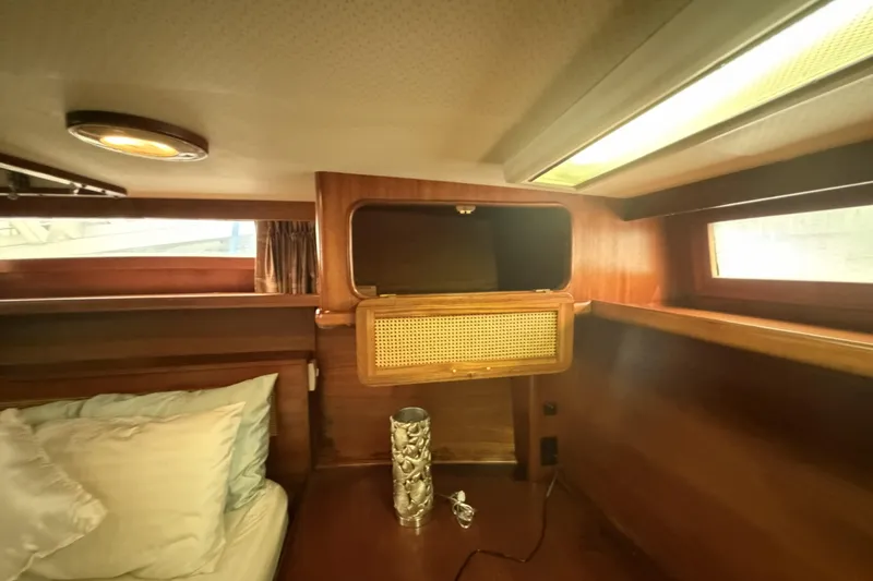 Slide: The Image of 1984 Gulfstar 49 Motor Yacht cabin interior with wood paneling and cozy bedding. - 66
