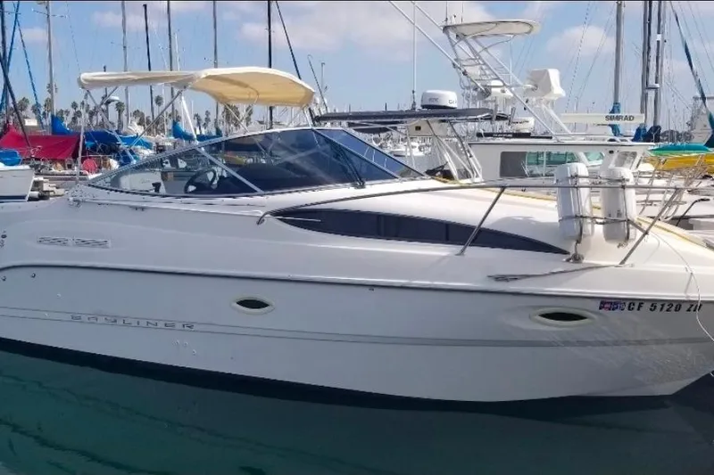 The Image of 2000 Bayliner 2655 Ciera Sunbridge boat docked in marina, featuring sleek design and canopy. - 0