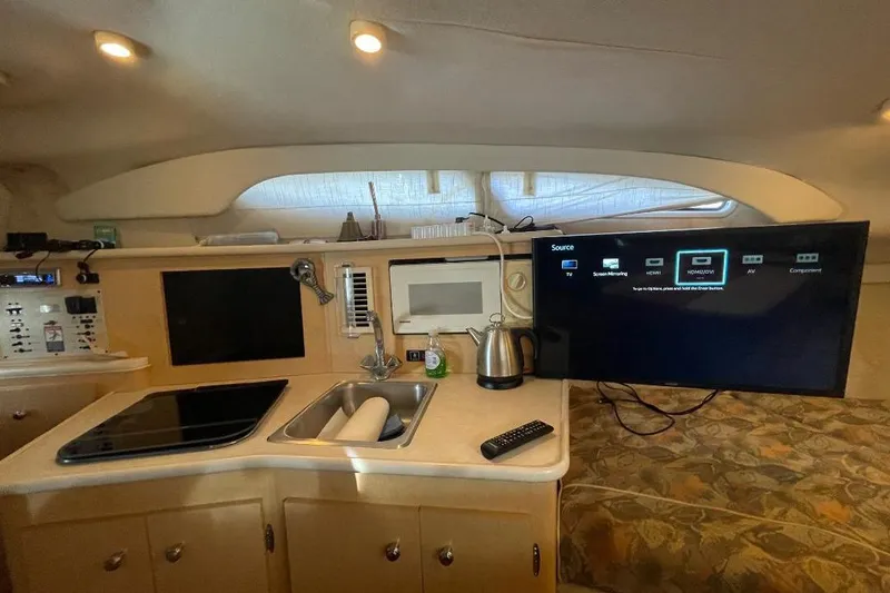 Slide: The Image of Interior of 2000 Bayliner 2655 Ciera Sunbridge with kitchenette and TV setup. - 6