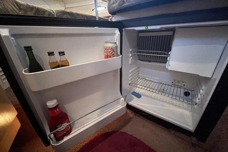 Slide: The Image of Mini fridge inside 2000 Bayliner 2655 Ciera Sunbridge, stocked with drinks and condiments. - 8