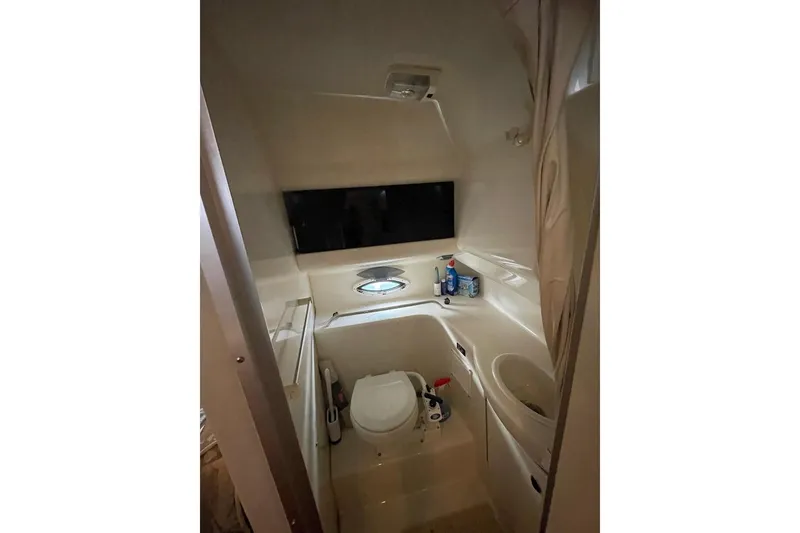 Slide: The Image of Compact bathroom in 2000 Bayliner 2655 Ciera Sunbridge boat, featuring toilet and sink. - 9