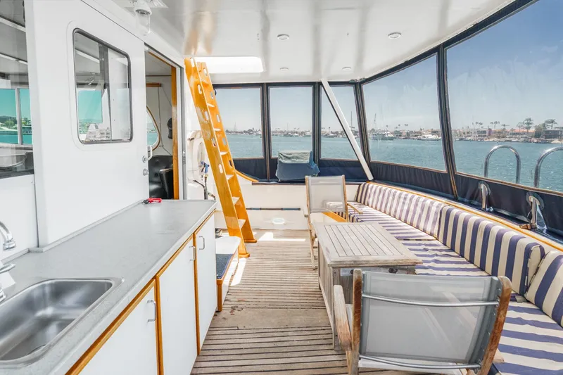Slide: The Image of 1963 DeFever Custom Skallerud & Sons yacht interior with striped seating and ocean view. - 10